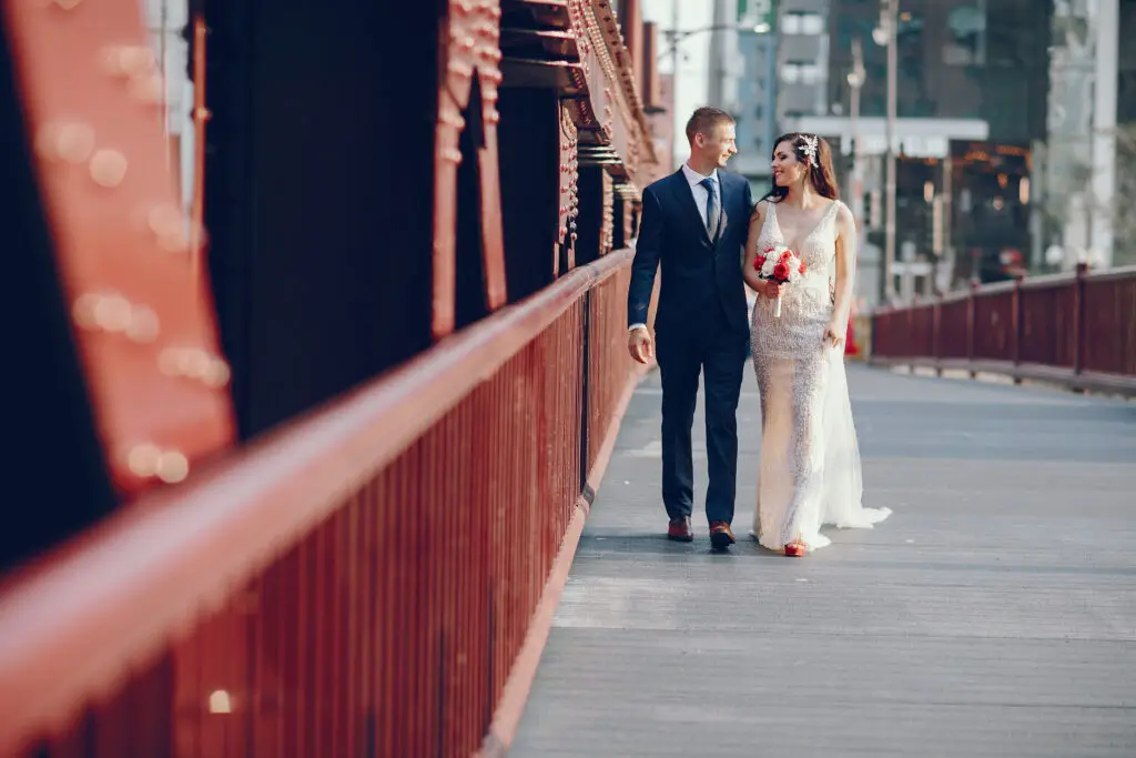Braut und Bräutigam auf Brücke mit Brautstrauß happy weddings und events Hochzeitsplanung